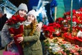 Young girl and her mother are buying Christmas ornamentals in the market outdoor.