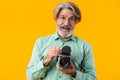 Positive grey-haired man photographer holding camera