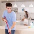 Positive guy and wife are cleaning kitchen Royalty Free Stock Photo
