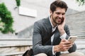 Positive handsome business man using mobile phone