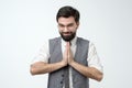 Positive handsome guy greeting with Namaste gesture his partner or coworker