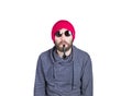 Positive handsome young bearded hipster in pink knitted hat smoking a pipe, expresses various emotions and shows Royalty Free Stock Photo