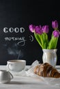 Positive and happy breakfast setting with tulips bouquest, coffee and croissant. Good morning Royalty Free Stock Photo