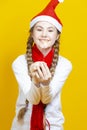 Positive Happy Caucasian Teenager Girl in Festive Santa Hat Having Fun With One Bengal Light Sparkler Posing Against Yellow