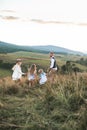 Positive happy family running in country field in summer time. Happy young family, father, mother and two children Royalty Free Stock Photo