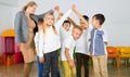 Positive female teacher playing circle game with children in classrom Royalty Free Stock Photo