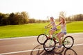 Positive happy girls in love ride bicycles on the park Royalty Free Stock Photo