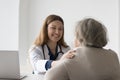 Positive happy practitioner seeing older patient, touching shoulder