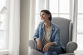 Positive happy pretty mature lady resting in comfortable armchair Royalty Free Stock Photo