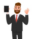 Positive happy young business man showing or holding blank screen of tablet computer display and gesturing, making okay, ok sign. Royalty Free Stock Photo