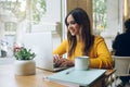 Positive hipster girl using laptop compute