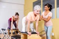 Hispanic woman pilates instructor helping aged woman exercising on wunda chair Royalty Free Stock Photo