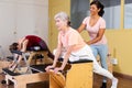 Hispanic woman pilates instructor helping aged woman exercising on wunda chair Royalty Free Stock Photo