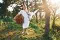 Positive housewife with hangs white clothes to dry. Young mother with her little son is outdoors in the forest. Beautiful sunshine Royalty Free Stock Photo