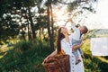 Positive housewife with hangs white clothes to dry. Young mother with her little son is outdoors in the forest. Beautiful sunshine Royalty Free Stock Photo