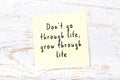 Positive inspiring quote handwritten on sticky note on wooden background