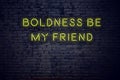 Positive inspiring quote on neon sign against brick wall boldness be my friend