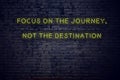 Positive inspiring quote on neon sign against brick wall focus on the journey not the destination Royalty Free Stock Photo