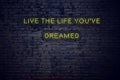 Positive inspiring quote on neon sign against brick wall live the life youve dreamed Royalty Free Stock Photo