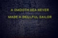 Positive inspiring quote on neon sign against brick wall a smooth sea never made a skillful sailor