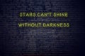 Positive inspiring quote on neon sign against brick wall stars cant shine without darkness