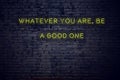 Positive inspiring quote on neon sign against brick wall whatever you are be a good one