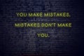 Positive inspiring quote on neon sign against brick wall you make mistakes mistakes dont make you