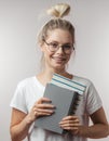 Portrait of young student girl with books isolated over grey wall background Royalty Free Stock Photo