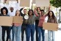 Positive international students walking by street with empty placards