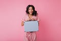 Positive Italian with brown eyes having fun in studio on pink background. Lady with baggage in hand Royalty Free Stock Photo