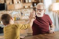 Positive joyful grandfather and grandson giving high five Royalty Free Stock Photo
