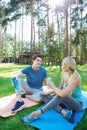 Positive joyful people sitting on yoga mats