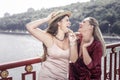 Positive joyful women standing on the bridge