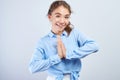 Positive Kazakh Asian girl with hands folded in prayer pose joyfully and friendly smiles looking at camera on white background Royalty Free Stock Photo