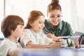 Outgoing teacher and children watching at appliance