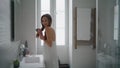 Positive lady arranging hair bathroom interior. Smiling woman holding hairbrush Royalty Free Stock Photo