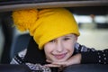 Positive little boy in a yellow knitted hat looks at the camera and smiles Royalty Free Stock Photo