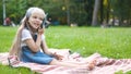 Positive little child girl having conversation on her mobile phone in summer park. Young female kid talking on sellphone Royalty Free Stock Photo