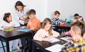 Positive little children with teacher drawing in classroom Royalty Free Stock Photo