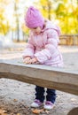 Positive little girl playing in the autumn park. Happy emotional child catches maple leaves. active holiday in autumn. leaf fall