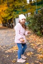 Positive little girl playing in the autumn park. Happy emotional child catches maple leaves and laughs. active holiday in autumn.