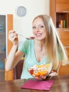 Positive long-haired blonde girl eating fruit salad Royalty Free Stock Photo