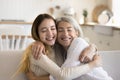 Positive loving teen girl hugging grandma with closed eyes