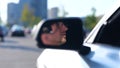 Happy young man sitting in the car while looking on the side view mirror, wearing glasses. Transport and lifestyle Royalty Free Stock Photo