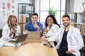 Multiracial doctors showing thumbs up at office meeting