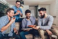 Positive male friends drinking beer and eating pizza at home