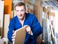 positive male worker standing with plywood pieces Royalty Free Stock Photo