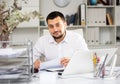 Positive man bookkeeper doing paperwork in office