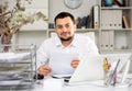 Positive man bookkeeper doing paperwork in office