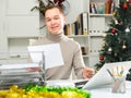 Positive man bookkeeper doing paperwork in office during Christmastime